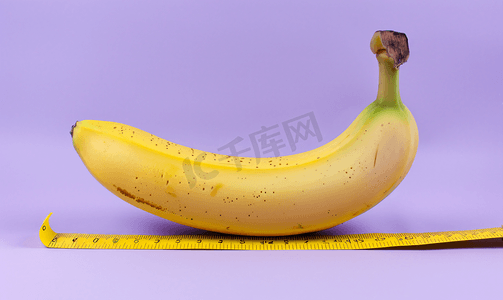搞笑水果摄影照片_紫色背景上使用黄色尺子测量香蕉成人材料
