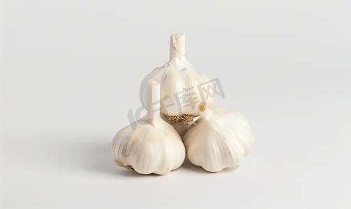 饮食金字塔摄影照片_白色背景中金字塔形式的大蒜三头大蒜
