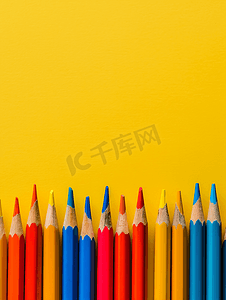 的铅笔摄影照片_黄色背景顶视图上的彩色铅笔回到学校概念