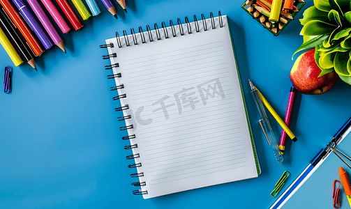 桌面书摄影照片_蓝色背景螺旋记事本上的学校笔记本在桌面教育上