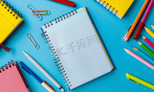 蓝色背景螺旋记事本上的学校笔记本在桌面教育上