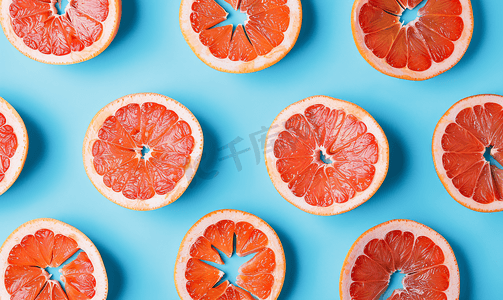 蓝色背景上多汁葡萄柚片的图案是一个美丽的图案
