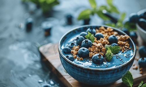 桌上有蓝莓和格兰诺拉麦片的冰沙碗有机抗氧化剂饮食食品