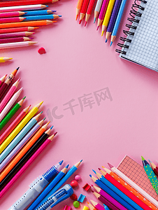 粉红色背景的学校用品文具钢笔铅笔记事本平躺