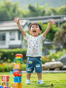 可爱小男孩在绿色草坪上玩玩具摄影图
