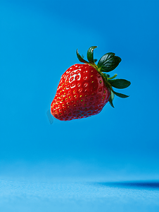 蓝色背景中悬浮的草莓浆果