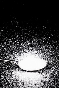 矿物盐摄影照片_黑色桌面的白色食用盐