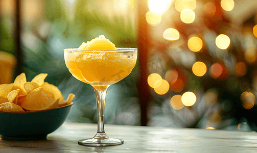 秋冬流行摄影照片_玻璃杯中的啤酒冰沙和桌上碗中的薯条是夏季流行饮品