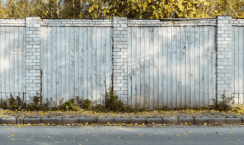 乡村街道上用灰色金属和白色砖块砌成的围墙
