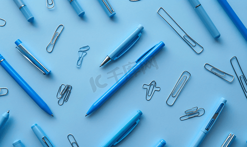 线元素摄影照片_钢笔、铅笔、圆规、回形针排成线全部为蓝色背景为