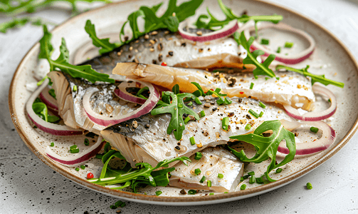 盘子里放着切片咸鲱鱼、洋葱和芝麻菜简单的小吃顶视图特写