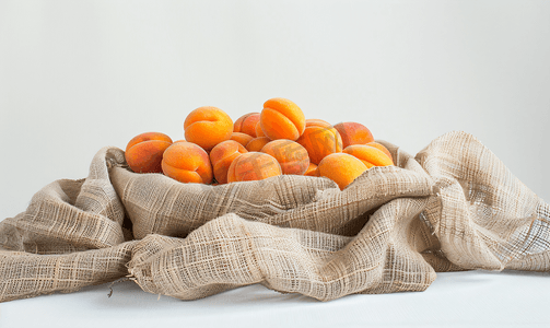 浓浓香味摄影照片_桌上麻布袋上的新鲜杏子