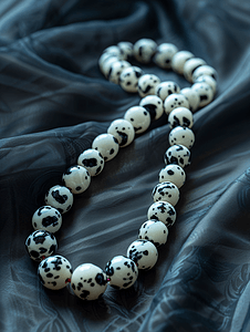 晶格渐变球体摄影照片_达尔马提亚碧玉宝石的珠子在黑暗中