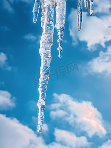 雪屋顶摄影照片_在蓝色多云天空背景的大冰柱