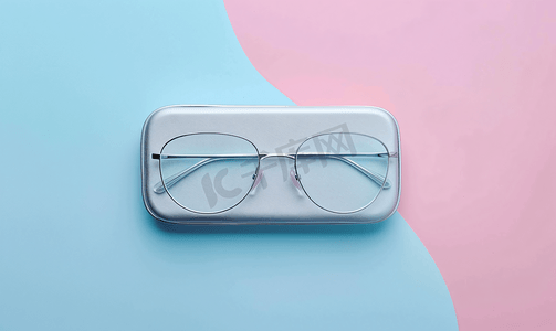 一副金属框眼镜和一个双色调背景的盒子