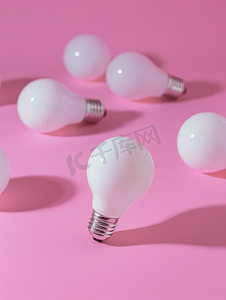 一个特殊的灯泡悬停在粉红色背景的简单标准白色灯泡上