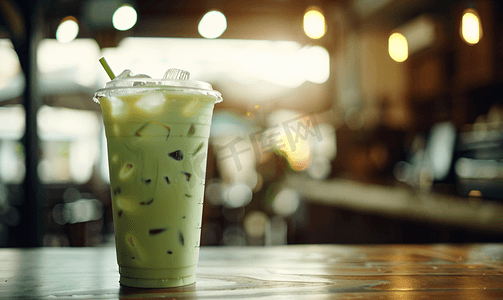 咖啡店木桌上的塑料杯中加牛奶的冰绿茶