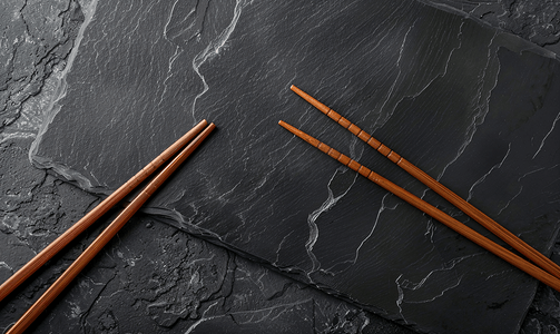 筷子提米摄影照片_黑色石板的顶部视图深色背景复制空间上配有木筷子