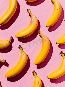 黄色几何创意摄影照片_粉红色背景上香蕉的几何图案