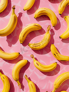 黄色几何创意摄影照片_粉红色背景上香蕉的几何图案从顶部看