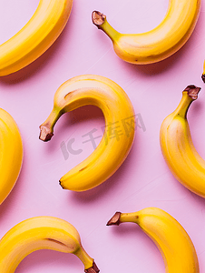 香蕉几何摄影照片_粉红色背景上香蕉的几何图案从顶部看