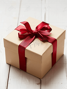可爱生日背景摄影照片_白色木质背景上有红丝带的礼品盒