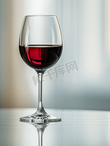 警示反光条摄影照片_酒吧里反光表面的一杯深红葡萄酒