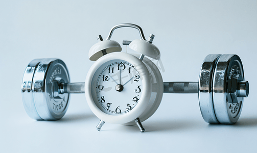 白色时钟和哑铃时间来设定锻炼计划时间和锻炼