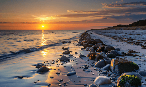 丹麦海滩上的日落石堤延伸至北海