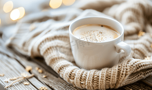 木桌上冬晨概念上的一杯热咖啡和针织毛衣