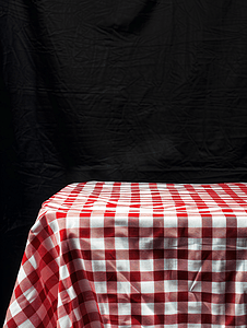 背景与红色和白色格子野餐桌布与深色背景