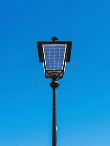 蓝天背景上带太阳能电池板的路灯