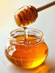横着的木棒摄影照片_用木棒浇注蜂蜜