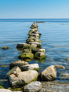 丹麦阳光明媚的风景中石堤伸入海岸附近的水中