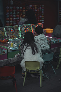 繁华的街景摄影照片_夜市上玩耍游戏机的孩子