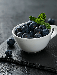 餐桌上的水果摄影照片_黑板上白杯中的有机蓝莓