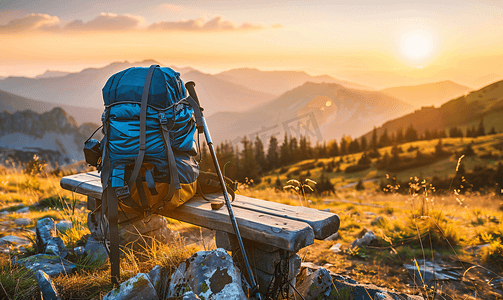 男休闲鞋摄影照片_日落旅游概念：背包和登山杖放在山顶的长凳上