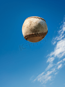 空中飞球摄影照片_蓝天背景的棒球在空中射击