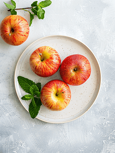 白盘上的自然静物烤苹果上面有薄荷叶