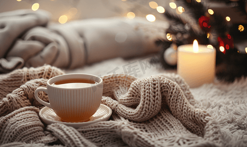 茶杯温暖毛衣蜡烛赠送礼物和杉树冬季家居舒适概念