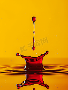 黄色背景上带有反射和滴落的红色液体飞溅