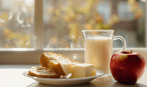 早餐包括容器中的新鲜黄油、面包、牛奶和苹果