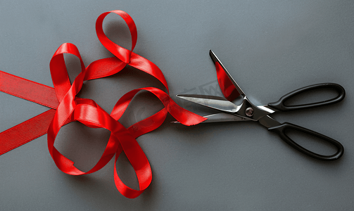 剪刀是灰色背景世界艾滋病日上的红丝带