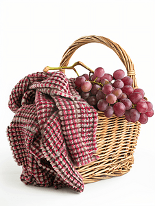 野餐篮葡萄和孤立的折叠毯子