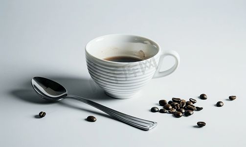 黑色的杯子摄影照片_带咖啡和勺子的杯子