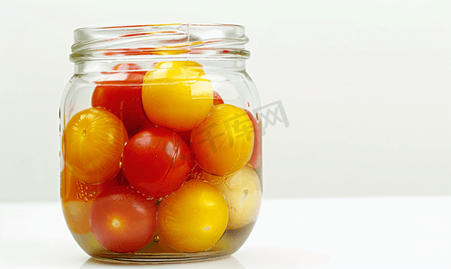 白色背景中玻璃杯中腌制的红黄番茄