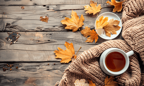秋叶木制背景横幅上的围巾旁边有一杯茶或咖啡