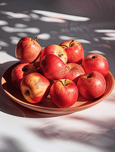 一盘新鲜的红苹果粘土碗及其周围有很多成熟的苹果
