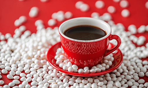 红色陶瓷杯白豌豆配热黑咖啡