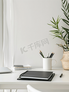 设计师或自由职业者黑色办公桌的工作场所配有文具和白墙